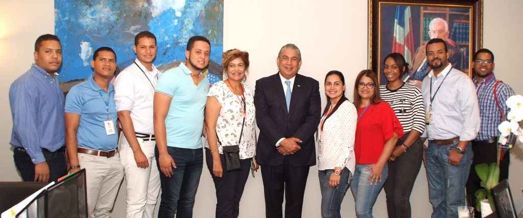 El cónsul Carlos Castillo junto a un grupo de jóvenes en la sede consular dominicana.