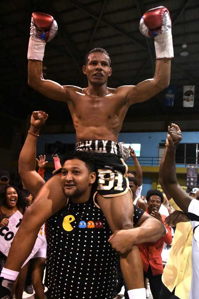 Derlyn Hernández es cargado por uno de sus fanáticos tras ganar el combate que lo convierte en el nuevo campeón nacional ligero junior.