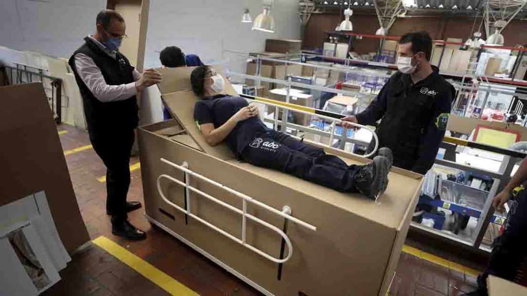 cama hospitalaria de cartón que se transforma en un ataúd