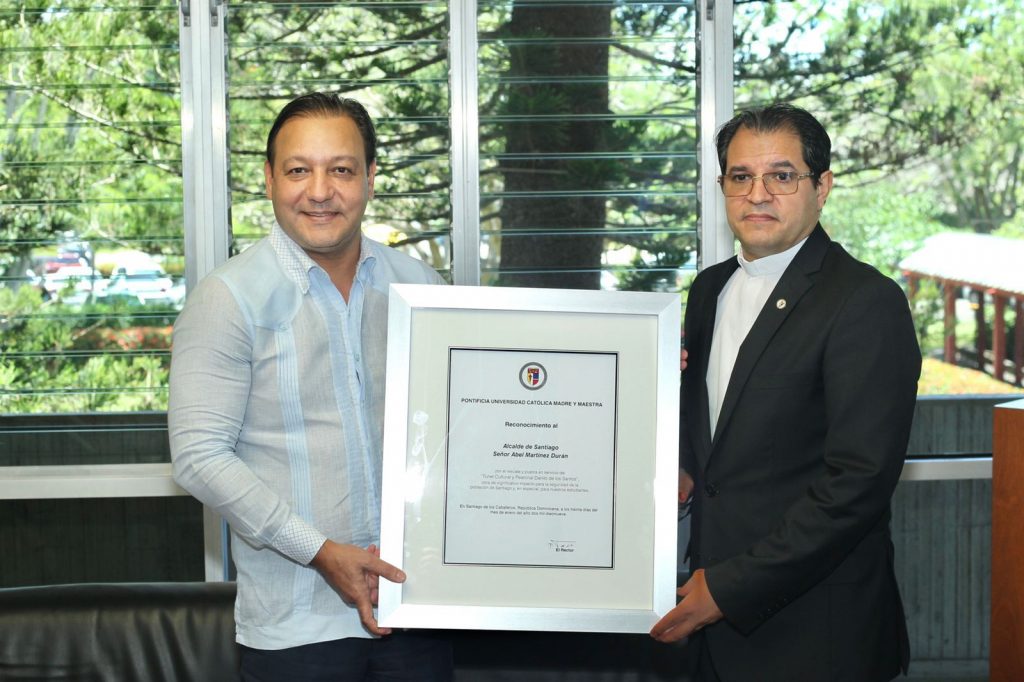 PUCAMAIMA reconoce al alcalde Abel Martínez por puesta en servicio túnel cultural y peatonal que da acceso a ese centro El rector de la PUCAMAIMA reverendo Secilio Espinal entrega reconocimiento al alcalde Abel Martinez