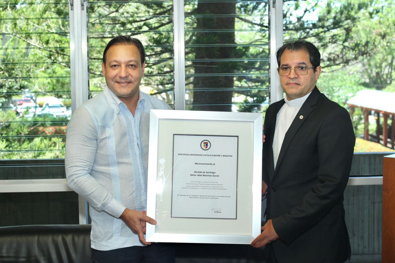 El rector de la PUCAMAIMA reverendo Secilio Espinal entrega reconocimiento al alcalde Abel Martinez
