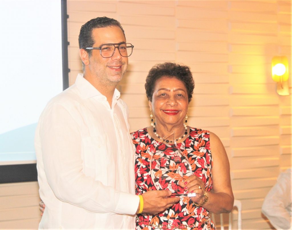El presidente de Fedocamaras Manuel Luna entrega a Perla Perez la placa de reconocimiento para Juan Maria Garcia Then