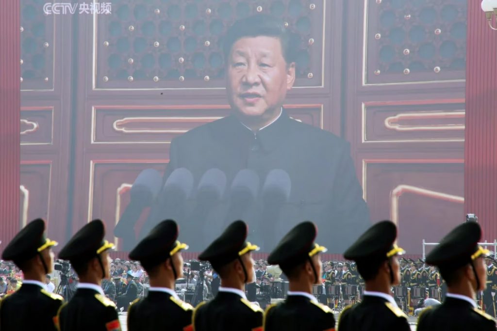 Xi Jinping en una pantalla frente a soldados del ejercito chino