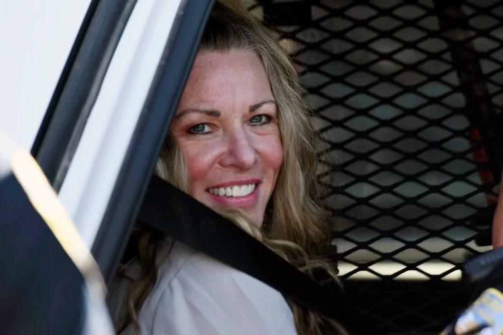 Lori Vallow Daybell sonrie sentada en un auto de la policia despues de asistir a una audiencia