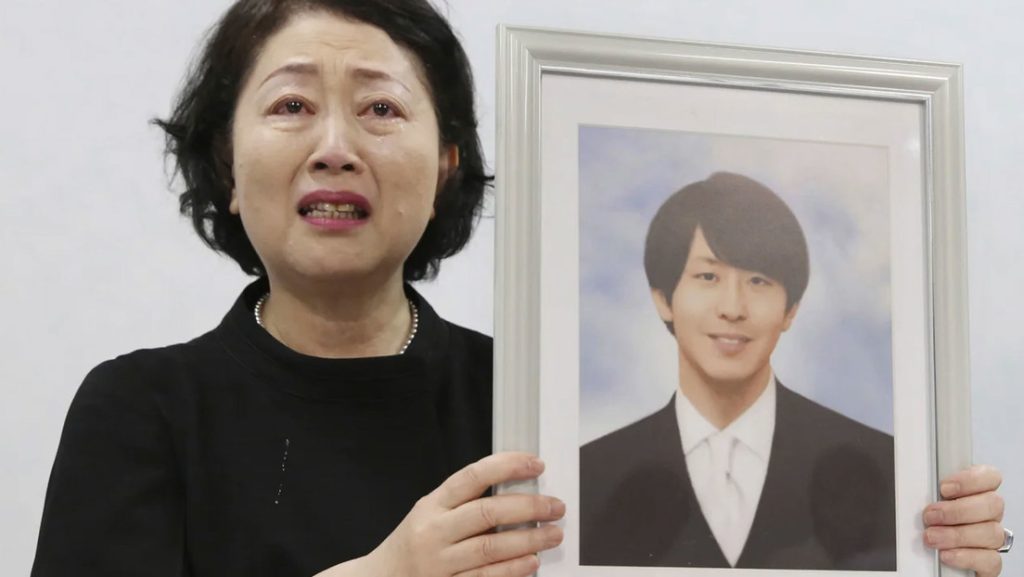 Junko Takashima la madre de Shingo Takashima muestra su fotografia en una conferencia de prensa