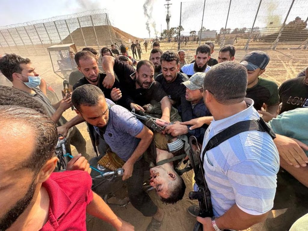 palestinos trasladan el cuerpo de un joven israeli asesinado en la frontera sur entre Israel y Gaza