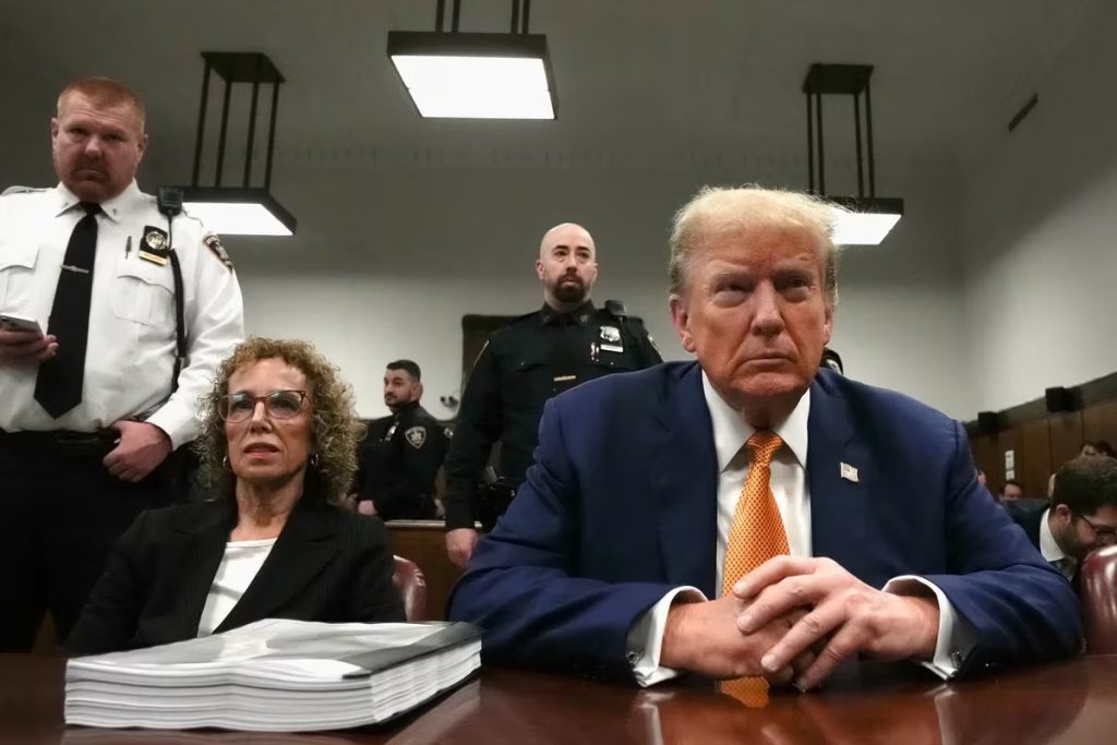 Trump mira al frente en la silla de la defensa de la corte de Manhattan donde es juzgado