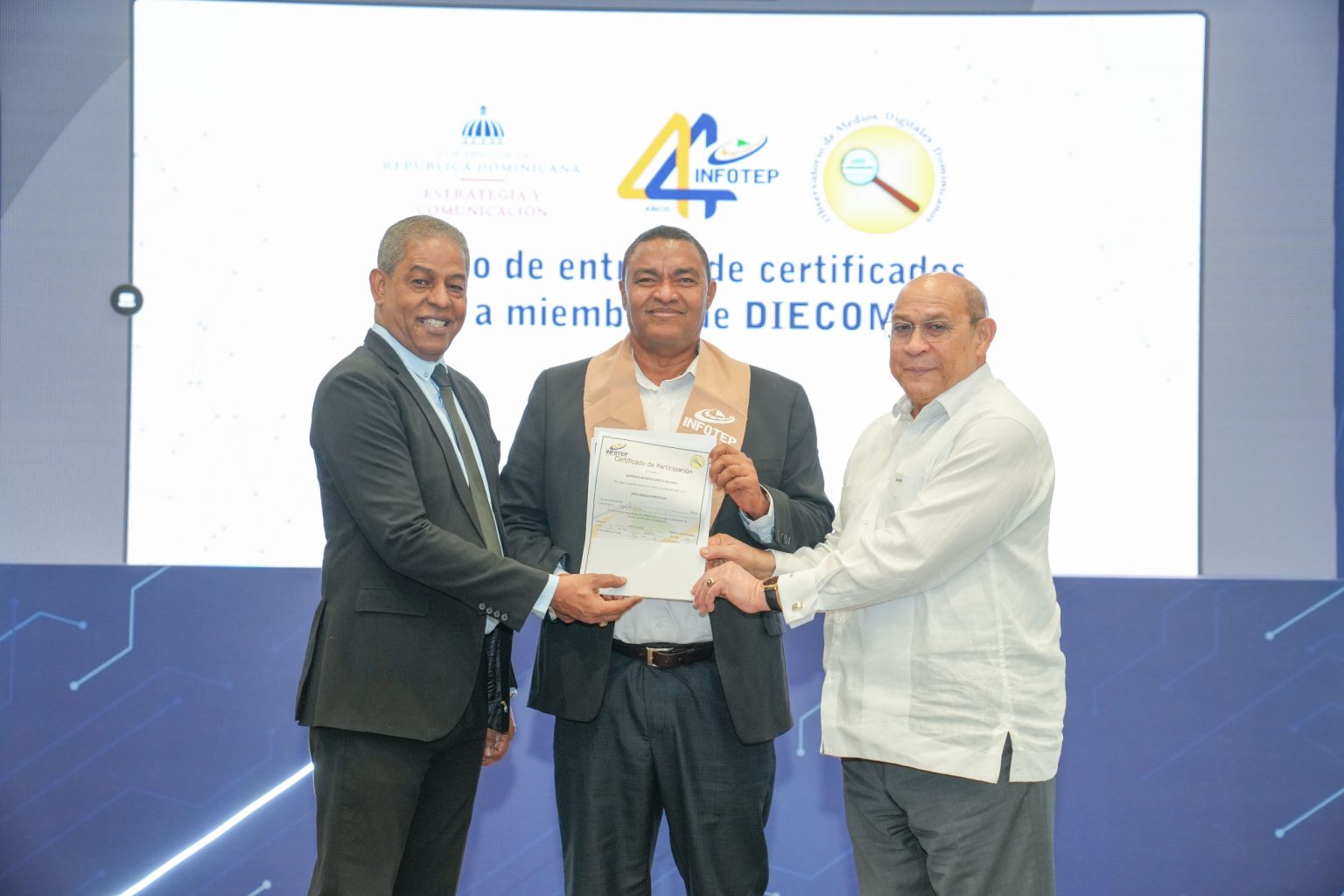 Federico Reynoso director de Medios de la Presidencia y Rafael Santos Badia entregan certificado a participante 2