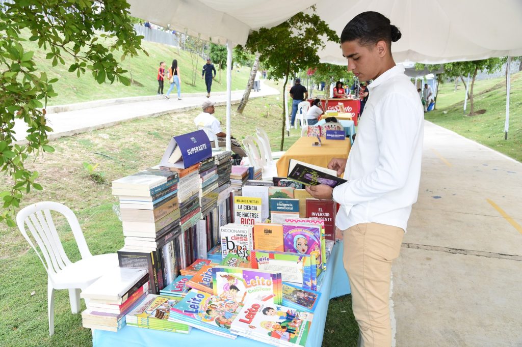 Cesar Hernandez deleitandose la lectura de un libro en el Stand Superarte