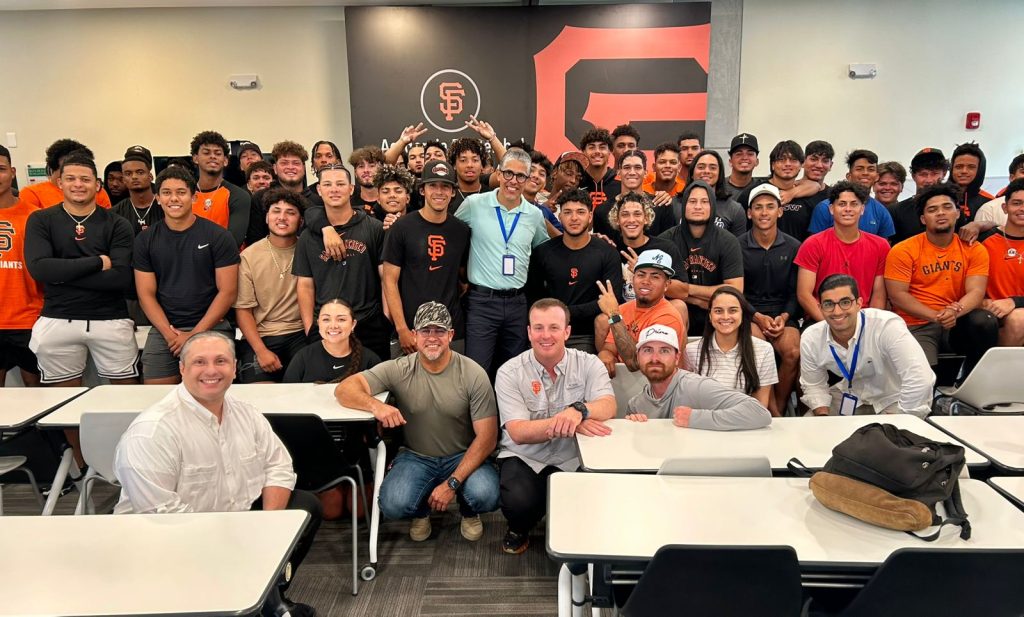 Grupo de novatos e instructores de los Gigantes de San Francisco posan junto a ejecutivos de la Dirección del Comisionado Nacional de Béisbol, quienes ofrecieron una charla motivacional y educativa a los prospectos de esa organización.