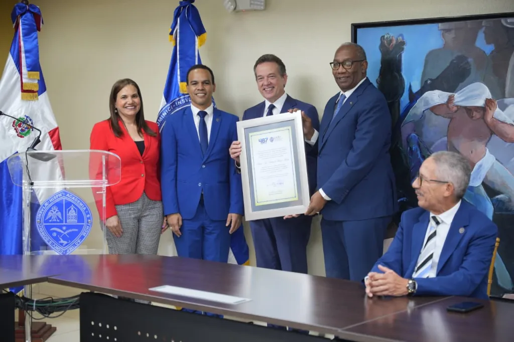 El rector de la UASD, maestro Editrudis Beltrán, mientras entrega el reconocimiento al ministro del MICM.